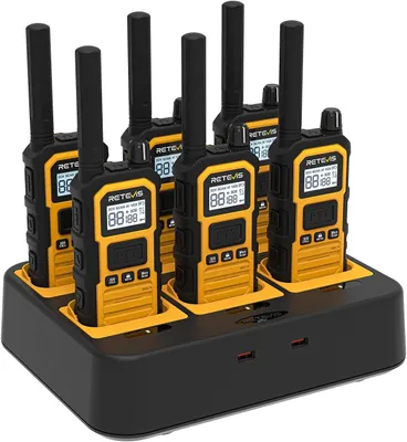 A set of six yellow and black walkie-talkies are neatly arranged in a black charging dock.