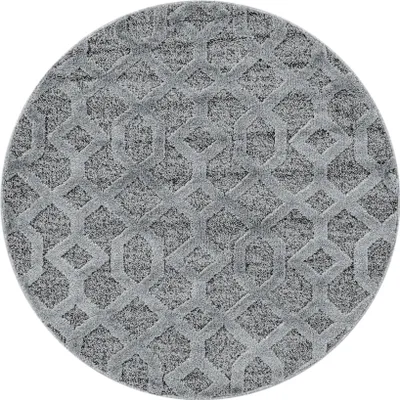 A circular gray rug with a geometric pattern.