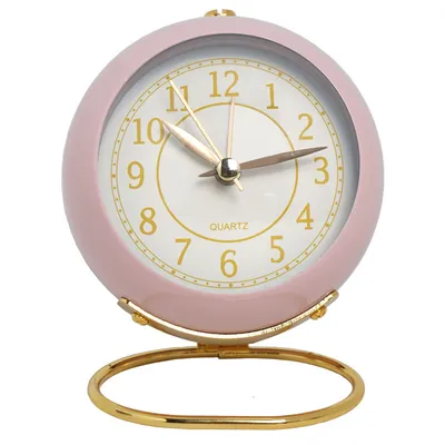 A pink analog alarm clock with a gold stand.