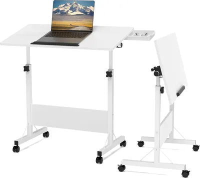 A white adjustable laptop table with a laptop on it, and a separate white board on a stand next to it.