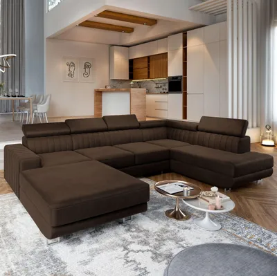 A spacious, modern living room with a large sectional sofa, kitchen area, and dining table.