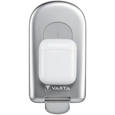 A white wireless charging case for earbuds is placed on a silver VARTA wireless charger.