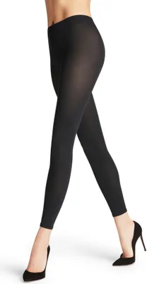 A person's legs wearing black leggings and black high heels, shown from the waist down against a white background.