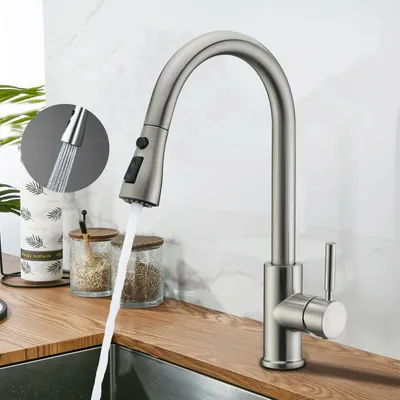 A kitchen faucet with water running into a sink, with decorative jars in the background.