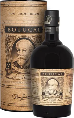 A bottle of Botucal rum and its cylindrical packaging.