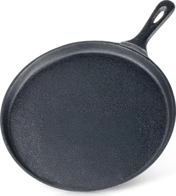 A black cast iron crepe pan shown from a diagonal angle, with the handle pointing towards the top right.
