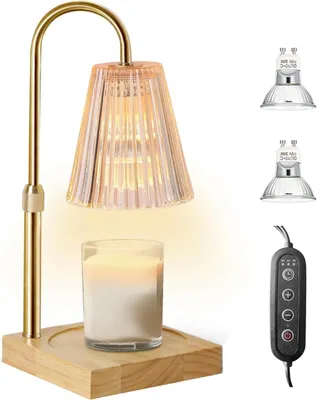 A candle warmer lamp with a glass shade and a candle on a wooden base, along with spare bulbs and a remote control.