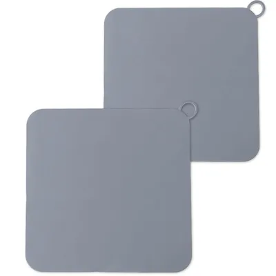 Two square silicone drain covers are shown against a white background. One is in the foreground, and the other is slightly behind and to the right.