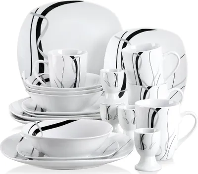 A collection of white porcelain dinnerware with black and gray abstract line designs, arranged in a display.