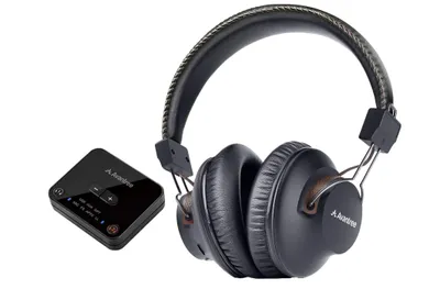 A pair of black wireless headphones and a small black Bluetooth transmitter are shown against a white background.