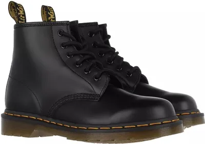A pair of black leather Dr. Martens boots on a white background.