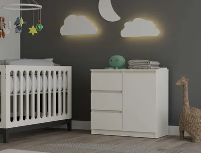 A nursery room with a crib, dresser, and giraffe decor.
