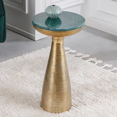 A decorative side table with a green marble top and a gold base, placed on a white rug.