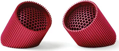 Two red cylindrical objects with hexagonal perforations are shown against a white background.
