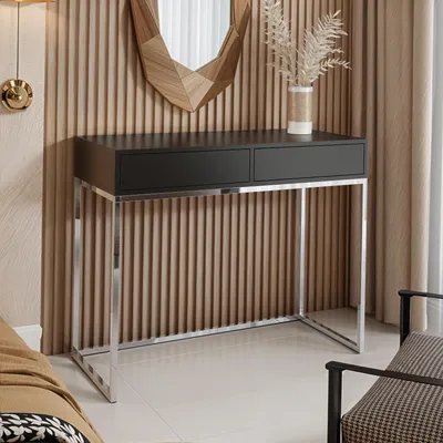 A modern black and chrome console table with two drawers, set against a fluted wood panel wall.