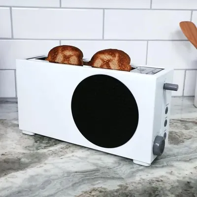 A white toaster with two slices of toast on a kitchen counter.