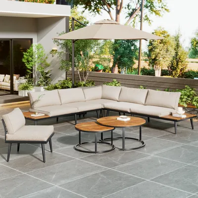 An outdoor patio scene with a sectional sofa, coffee tables, and an umbrella.