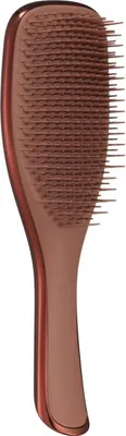 A close-up studio shot of a bronze-colored hairbrush against a white background.