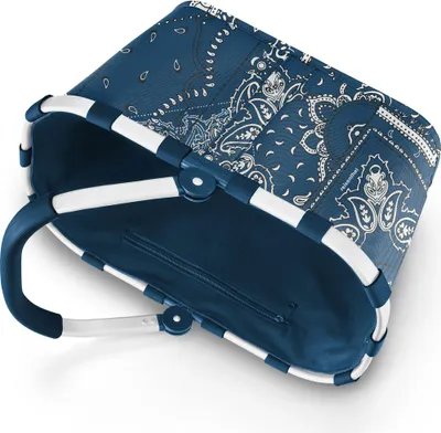 A blue and white patterned shopping basket with white handles.