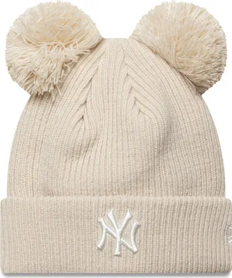A beige knitted winter hat with two pom-poms on top and the New York Yankees logo on the front.