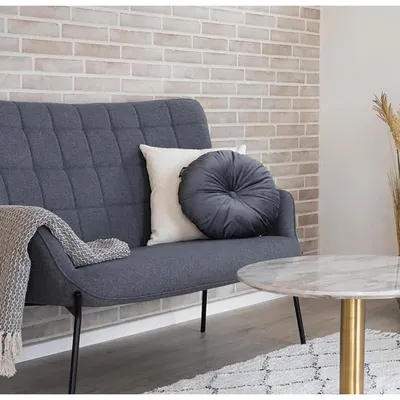 Image de Coussin rond en velours, de couleur grise.