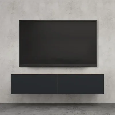 A wall-mounted TV stand with a TV above it, against a concrete wall.