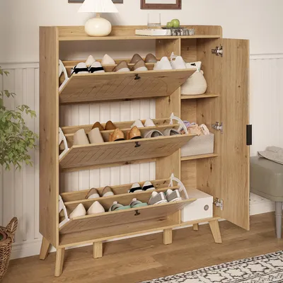 A wooden shoe cabinet with multiple flip-down compartments is shown in a room setting, with a plant and a stool nearby.