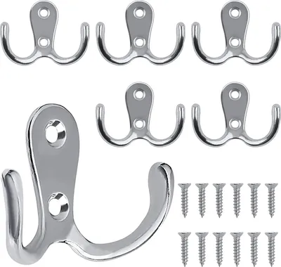 A collection of double-pronged coat hooks and screws on a white background.