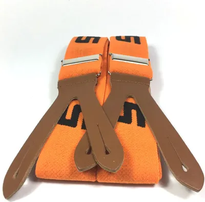 A pair of orange suspenders with brown leather attachments and black lettering is displayed against a white background.