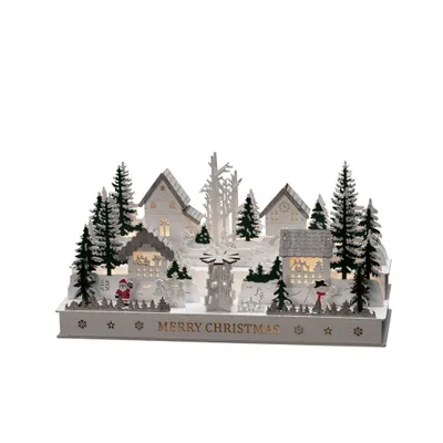 A miniature Christmas village scene with houses, trees, and figures, illuminated by warm white lights.