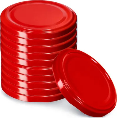 A stack of red jar lids with one lid placed in front of the stack.