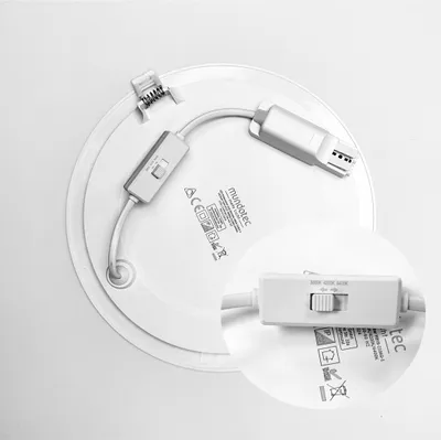 The back of a round, slim LED panel light with visible wiring and a switch.