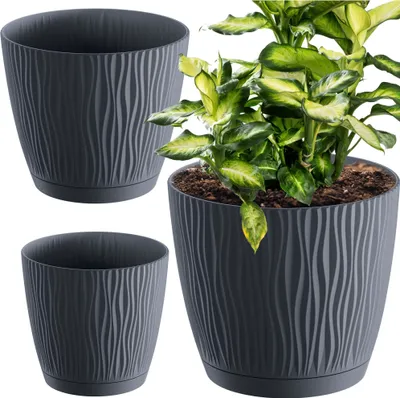 Three dark gray planters with a wavy texture, one of which contains a green plant.