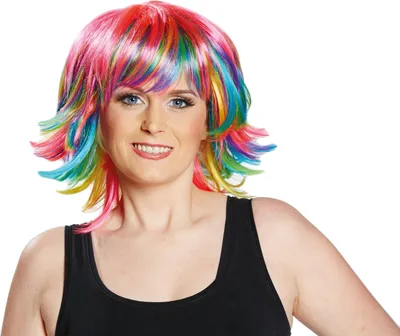 A woman wearing a colorful wig and a black tank top, posing against a white background.