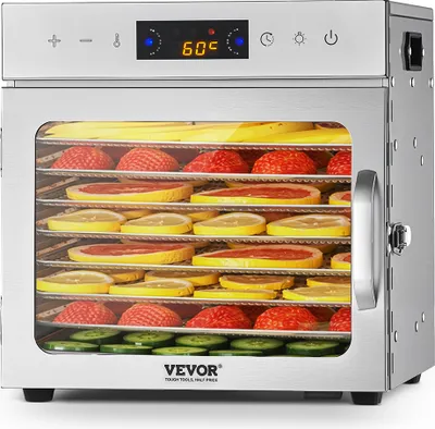 A stainless steel food dehydrator filled with various fruits and vegetables on its trays, with a digital display showing the temperature.