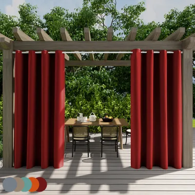 Outdoor curtains hanging on a pergola over a table and chairs on a wooden deck.