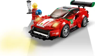 A LEGO Ferrari race car with two minifigures, one holding a trophy.