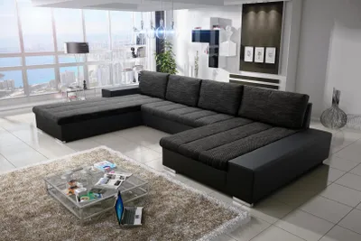 A modern living room with a large sectional sofa, a glass coffee table, and a large window overlooking a city skyline.