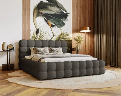 A bedroom scene featuring a dark gray upholstered bed with a large mural of a bird on the wall behind it.