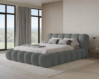 A modern bedroom with a large, upholstered bed as the focal point, featuring large windows with a view of greenery.
