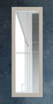 A full-length mirror with a light wood frame is mounted on a dark, textured wall.