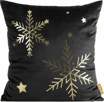 A black pillow with gold snowflake and star designs.