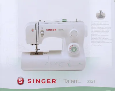 A white Singer sewing machine with green decorative accents on a white background.