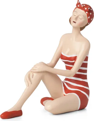 A figurine of a woman in a striped swimsuit and headscarf, sitting with her eyes closed.