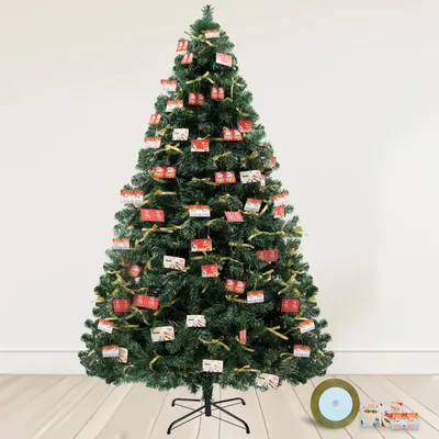 A decorated artificial Christmas tree standing on a wooden floor against a plain wall.