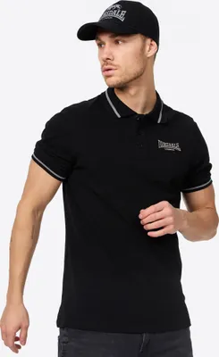 A man wearing a black Lonsdale polo shirt and a black baseball cap.