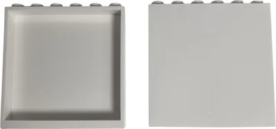 Two white LEGO bricks are shown side-by-side against a white background. The brick on the left is shown from the front, revealing its hollow interior and studs on top. The brick on the right is shown from the back, with a smooth surface and a small circula