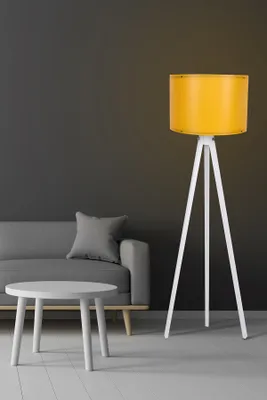 A modern living room scene with a gray sofa, a white side table, and a white tripod floor lamp with a yellow shade.