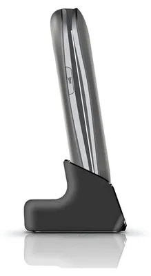 A side view of a gray and silver mobile phone resting in its charging cradle.