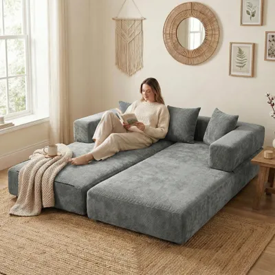 A woman is reading a book on a modular sofa in a living room.